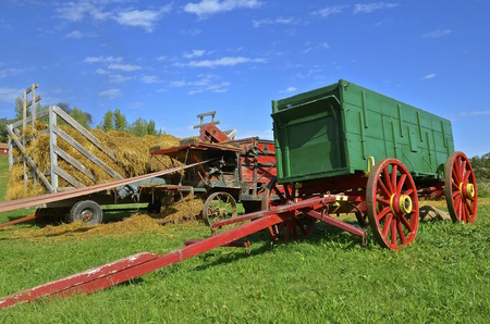 An old green wagon with a long hitch is used to haul grain from threshing.の写真素材