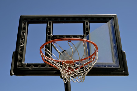 The plexiglass of a backboard is broken on an outdoor basketball court.の写真素材