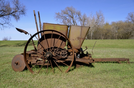 Old rusty potato planter with metal hoppers for holding the seedの写真素材