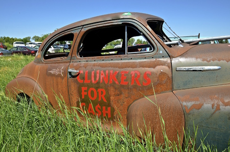 An old rusty car in a junkyard is used as an advertisement of paying cash for clunkersの写真素材