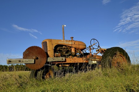 GARFIELD, MINNESOTA, October 21, 2016:  The tractor with an attached saw blade is an Allis Chalmersllis-Chalmers, a U.S. manufacturer of machinery for various industries includung agricultural equipment, construction, power generation, and power transmissのeditorial素材