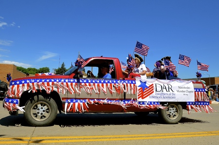 MANDAN, NORTH DAKOTA, July 3, 2016: The 4th of July Rodeo Days  3 day celebration includes the rodeo, Art in the Park, and downtown parade where a patriotic decorated pickup transports Daughters of the American Revolution.のeditorial素材
