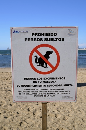A sign by the  city of Mazatlan in the Spanish language indicate dogs pooping along the street and beach is prohibited.の写真素材