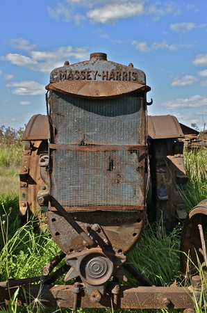BARNESVILLE, MINNESOTA, September 14, 2014: The Massey Harris name on the rusty tractor with missing parts disappeared when a merger of Massey Harris and the Ferguson Company farm machinery manufacturer occurred in 1953, to become Massey Ferguson.のeditorial素材