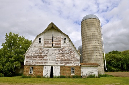 Front view of a former hip roofed dairy barn with hayloft and siloの写真素材