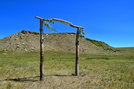 Decorated poles  in Standing Rock Reservation in front of a huge butte honoring Native Americansのeditorial素材