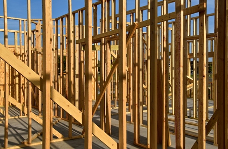 A building resting on a concrete pad with no basement is in the process of being framed