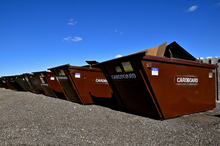 Dumpsters for collecting cardboard and recyclables stand in a row at at depository collection site.の写真素材