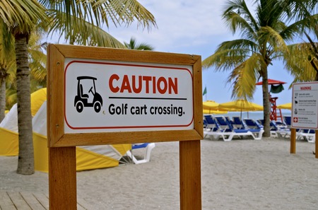 A beautiful painted wood sign at a tropical Caribbean beach warns pedestrians of a Golf Cart Crossing area.の写真素材