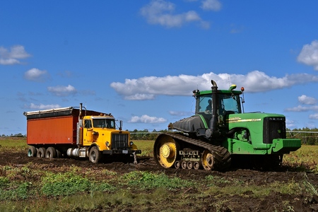 OSAGE, MINNESOTA, Sept 26, 2017: The 9620 T tractor pulling a truck stuck in mud is a product of John Deere Co, an American corporation that manufactures agricultural, construction, forestry equipment, machinery, and diesel engines,のeditorial素材