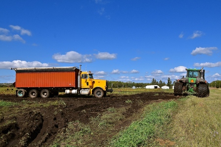 OSAGE, MINNESOTA, Sept 26, 2017: The 9620 T tractor pulling a truck stuck in mud is a product of John Deere Co, an American corporation that manufactures agricultural, construction, forestry equipment, machinery, and diesel engines,のeditorial素材