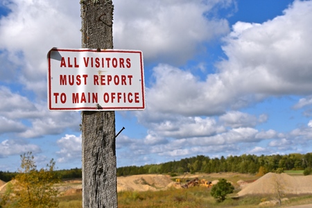 Visitors Must Report To Main Office` sign at a large gravel pit.の写真素材