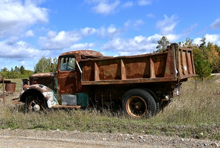 PARK RAPIDS, MINNESOTA, September 26,  2017:  An old Mack gravel truck parked in the weeds is from a company founded in 1900, had it's first truck produced in 1907.のeditorial素材