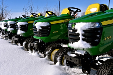 MOORHEAD, MINNESOTA, March 5, 2018 : The John Deere  lawn tractor  covered with snow are products of  John Deere Co, an American corporation that manufactures agricultural, construction, forestry machinery, and diesel engines.のeditorial素材