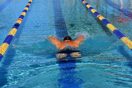 Unidentified swimmer swims laps in an outdoor swimming pool