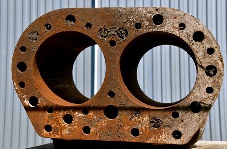 Rusty block of an old tractor engine exposing the space for the cylinders