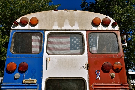 An old school bus has been painted red, white, and blue as it was converted into a patriotic camper.の写真素材