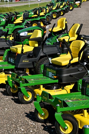 HAWLEY, MINNESOTA, August 22, 2017: A row of green and yellow new riding lawn mower tractors are...