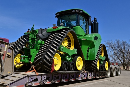 ALEXANDRIA, MINNESOTA, April 22, 2018: The tractor being hauled on a flat bed trailer  is a 9620RX, ...