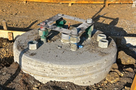 Circular concrete  shape in the ground with anchor bolts which will serve as the base to hold a traffic light  steel column.の写真素材