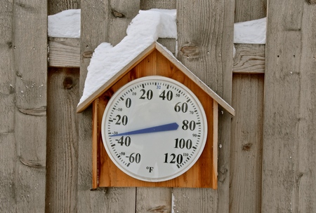A snow covered thermometer records a chilly negative 32 degrees Fahrenheit.の写真素材
