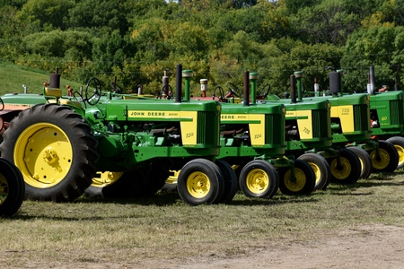 ROLLAG, MINNESOTA, September 2, 2018: A row of old restored John Deere 720, 730, and 60 tractors are...