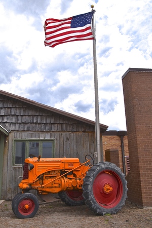 HILLSBORO, NORTH DAKOTA, May 10,2019:  The old Minneapolis Moline R tractor under a flag pole was from the company based in Minnesota, and was the product of a merger between three companies in 1929: Minneapolis Steel & Machinery (MSM), Minneapolis Thresのeditorial素材