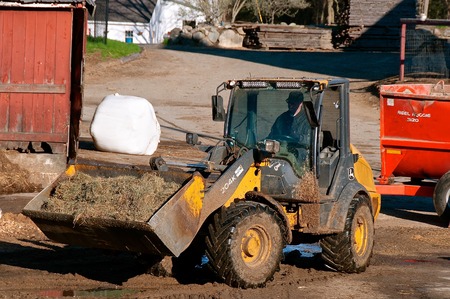 ROWLEY, MASSACHUSETTS, April 28, 2019: The 204K John Deere front end loader hauling silage is a...