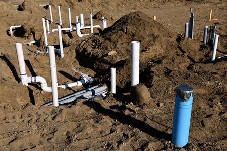 Pvc pipe is installed and buried under the ground prior to the cement floor being poured on a new construction site.の写真素材