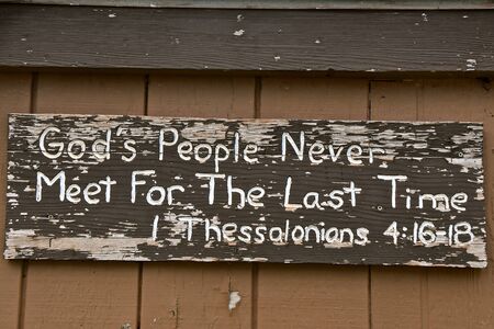 Bible verse on an old peeling wooden sign from Thessalonians referring to God's peopleの写真素材