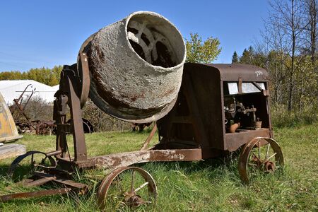 An old concrete mixer on wheels was powered by a gas engine.の写真素材