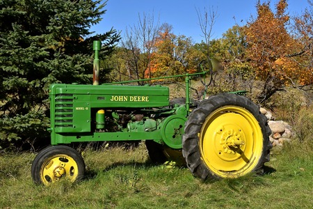 VERGAS, MINNESOTA, October 2, 2019: The old  Model H John Deere tractor against autumn leaves is a product of John Deere Co, an American corporation that manufactures agricultural and construction equipment, drive trains, and transmission.のeditorial素材