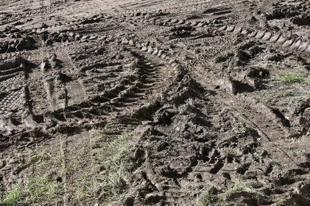 Tractor tire tracks are left imprinted in the mudの写真素材