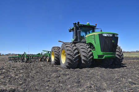 MOORHEAD MINNESOTA, April 29, 2020: The John Deere farming machinery digging a field next to a new...