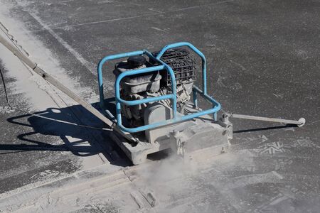 A power cement machine blade and machine cut an expansion line on a freshly poured concrete floor.