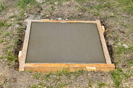 Forms set in square for freshly poured concrete to serve as a foundation and base for a future fountain.の写真素材