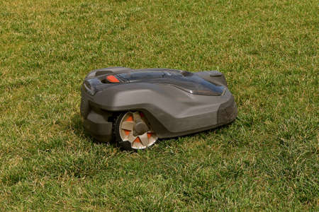 Robotic lawn mower moves over the grass without human assistanceのeditorial素材