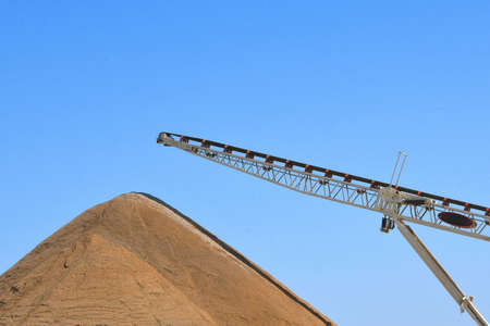 A conveyor belt which drops sand creating a hug e pile for construction projects