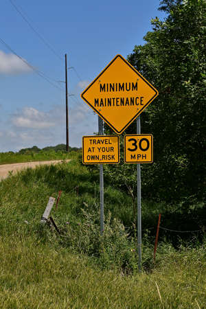 A rural minimum maintenance road posts a sign enforcing the speed limit at 30 mph.の写真素材