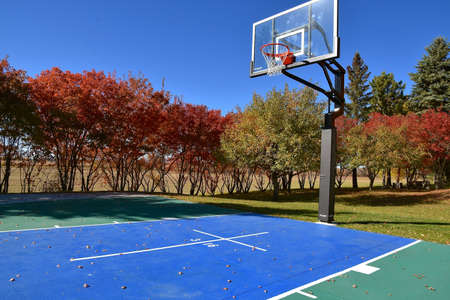 A half court of outdoor basketball with outdoor flooring and a cross with 3 and 16 inscribed.の写真素材