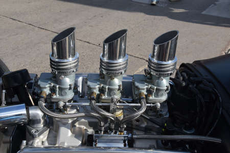 Three sets of chrome carburetors on the engine of a tree hot rod