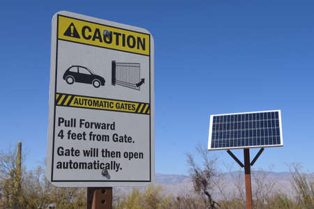 A sign explaining how the gates open automatically at a desert park with a door panel in the...