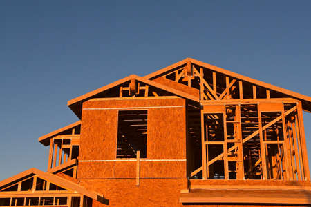 A new house in the framing process receives the early morning sun rays.の写真素材