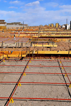 Rebar creates square grids at the construction site of a concrete pad in a huge housing developmentの写真素材