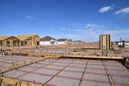 Rebar creates square grids at the construction site of a concrete pad in a huge housing developmentの写真素材