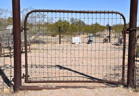 An old metal rusty gate leading to a backyard sitting space.の写真素材