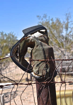 An old cowboy boot decorate the top of a fence post.の写真素材