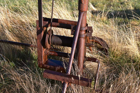 Closeup of an old rusty wench and cable to lift the shaft of an old grain elevatorの写真素材