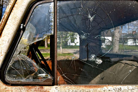 The windows of an old pickup are shattered and broken.の写真素材