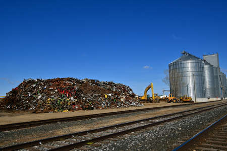 A huge pile of scrap metal and iron  adjacent to railroad tracks ready to be loaded.の写真素材